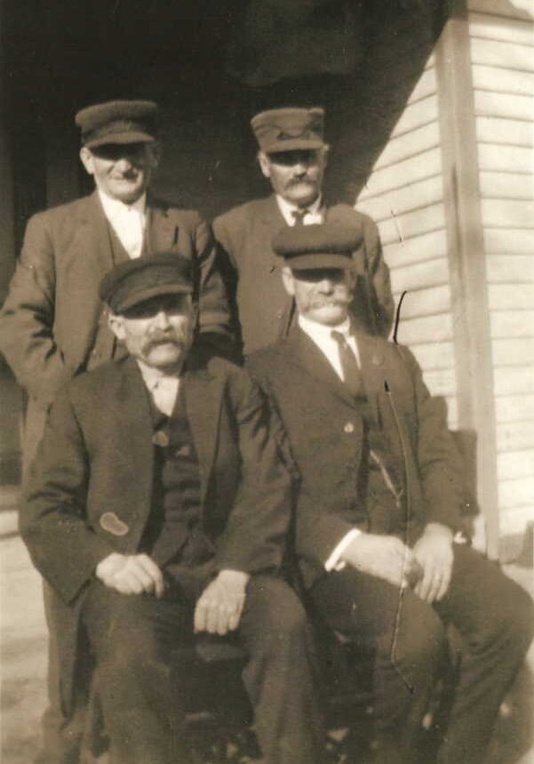 (Left to right) (Back row) Henry John Schmidt, Georg Karl "Charles" Schmidt. (Front row) Michael "Mike" Lindemann, John A. Lindemann. (Henry and Karl were first cousins. Mike and John were also first cousins. The Schmidt men were also more distant cousins of the Lindemann men. Mike Lindemann's sister, Maggie, married Karl Schmidt. Mike's wife, Lizzie, was Henry Schmidt's sister. John A. Lindemann, Mike's cousin from Iowa City, often left off an "n" from his last name and spelled it "Lindeman".) Photo courtesy of Denise Lindemann.